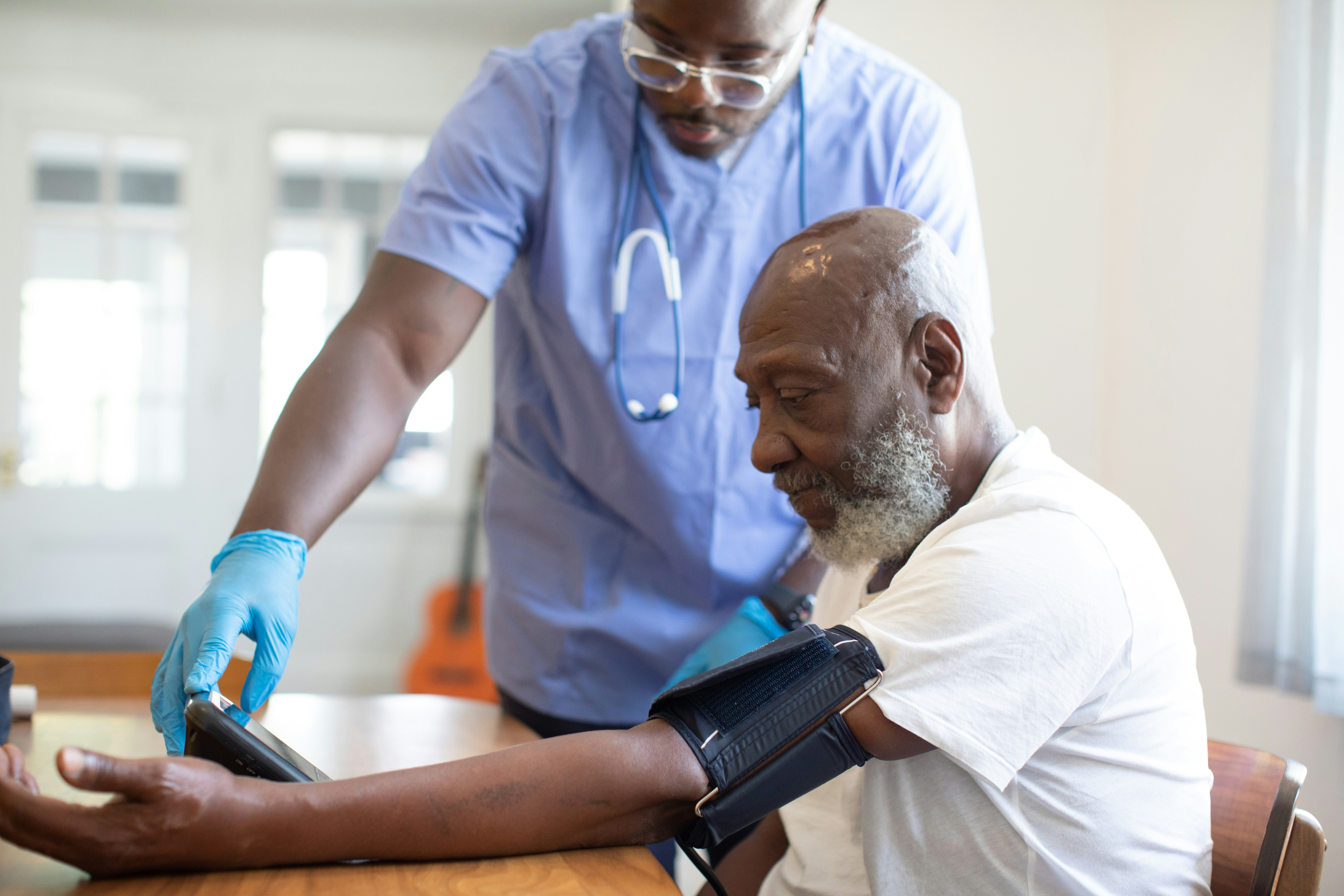 A nurse checking an elderly patient’s blood pressure